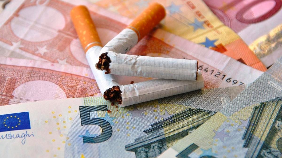 Cigarro roto sobre billetes de euros