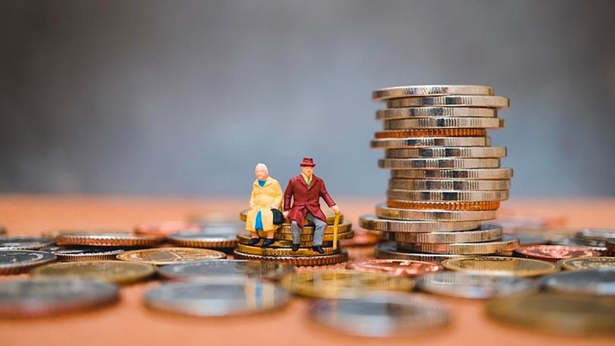 Dos figuritas que representan dos pensionistas sentados sobre unas monedas de euro