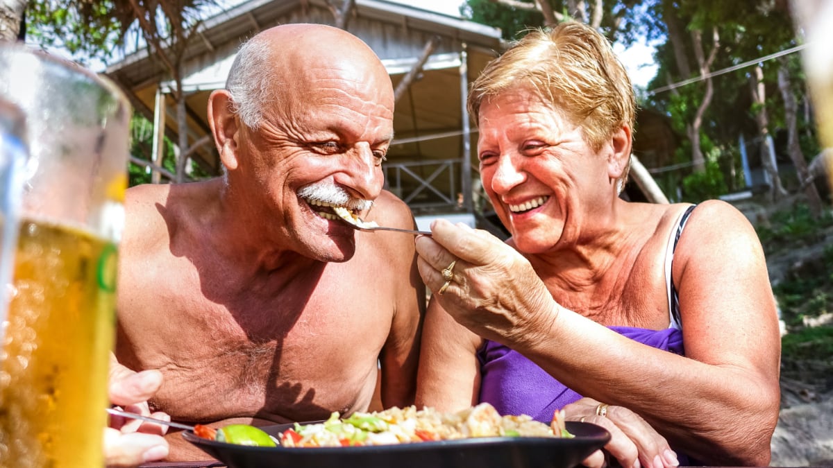 Dos personas ancianas comiendo en sus vacaciones