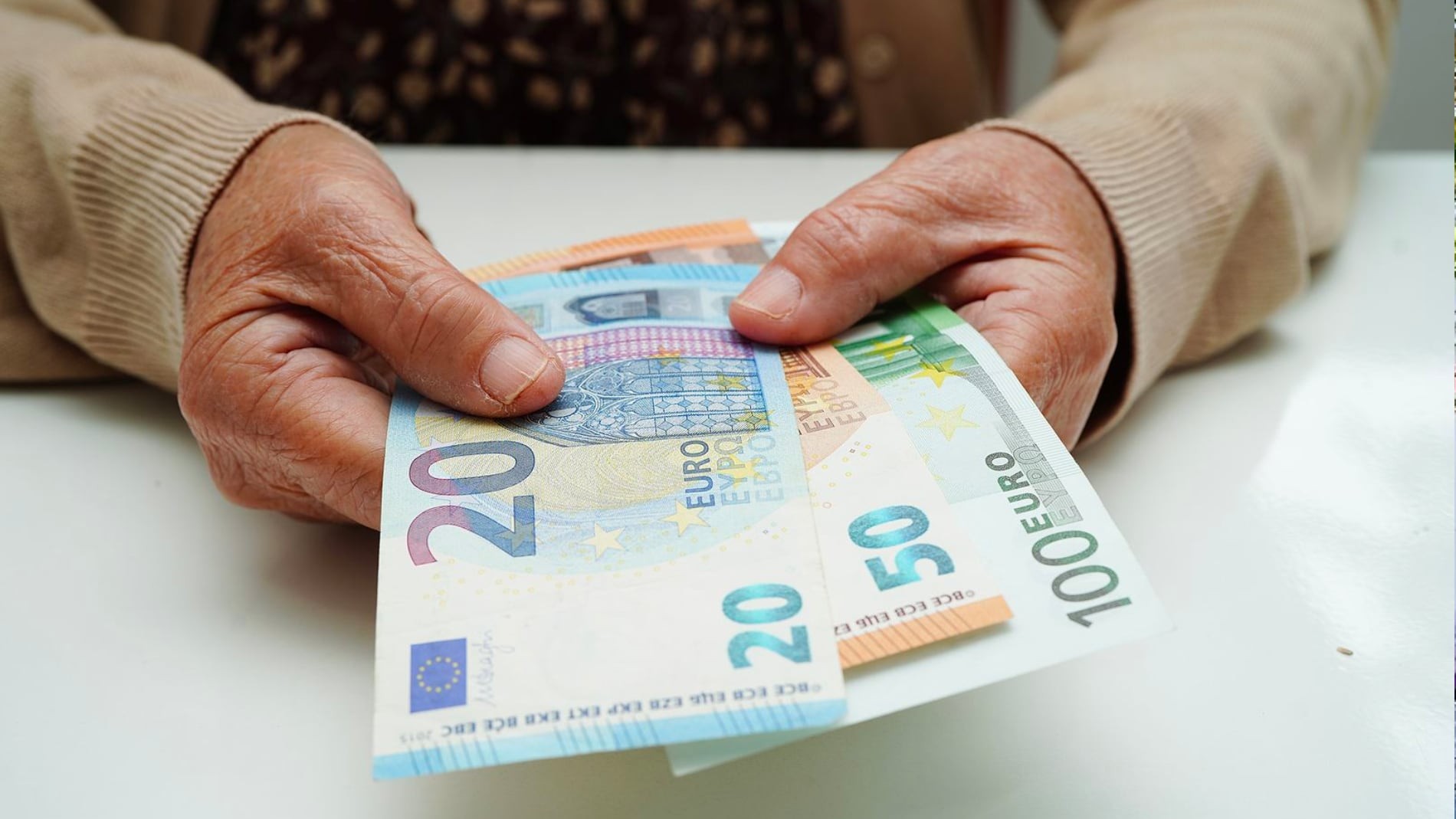 manos sosteniendo billetes de euros
