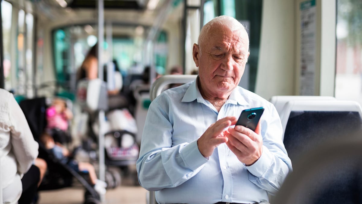 pensionista sentado mirando el móvil