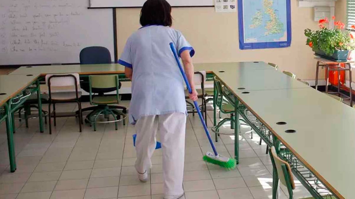 una mujer trabajando como personal de limpieza en un colegio