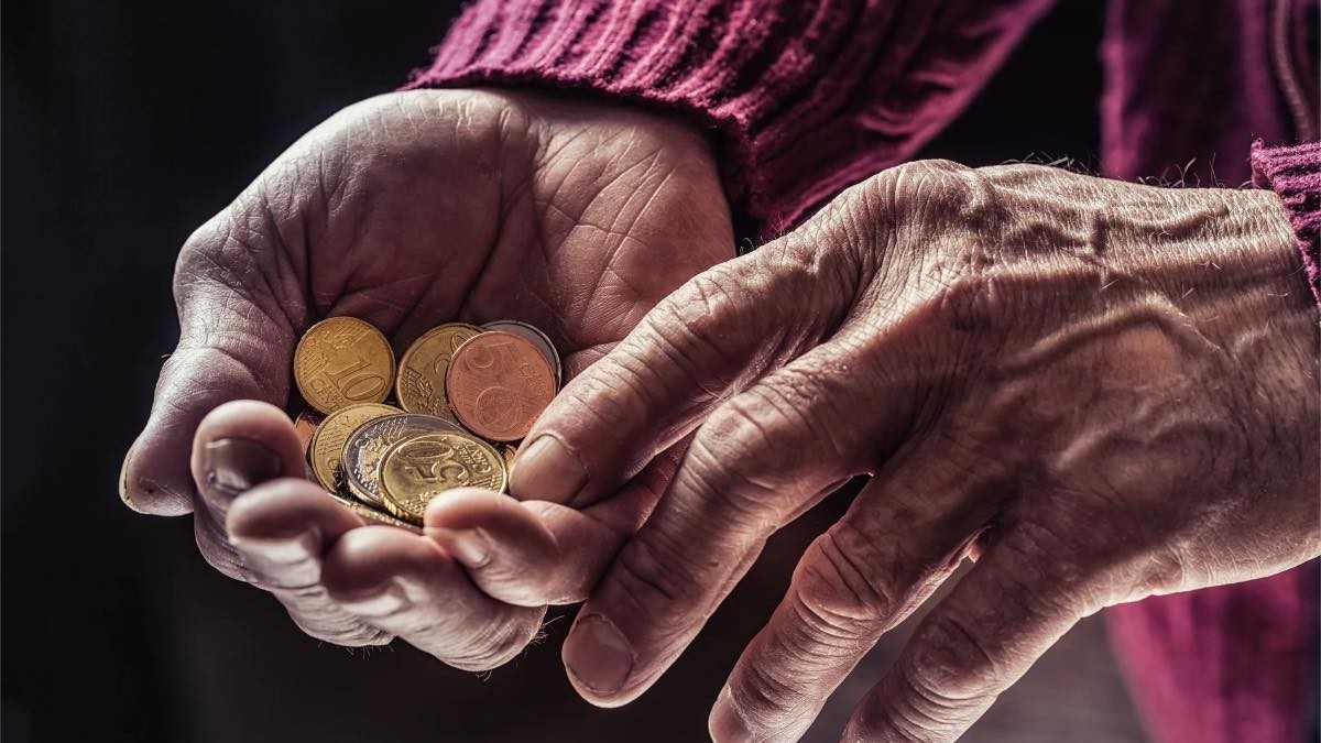 Jubilado contando varias monedas de euro