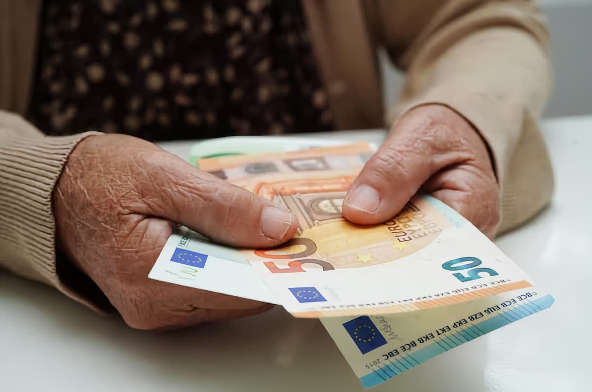 Una mujer anciana sostiene varios billetes de euros