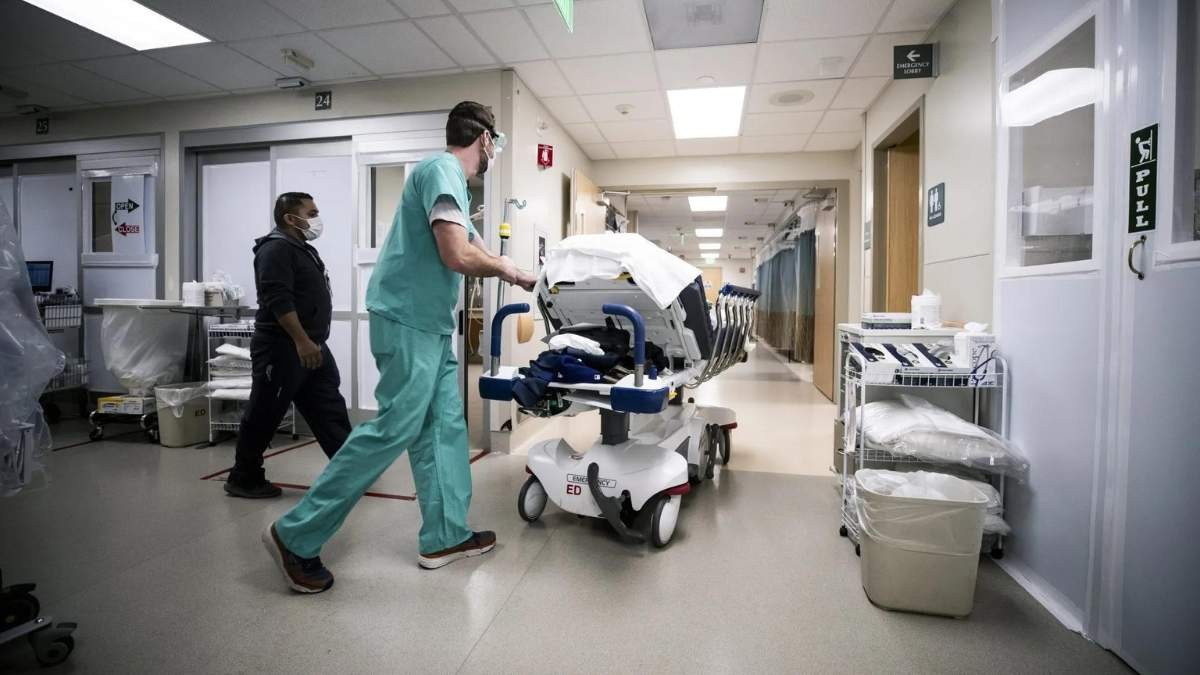 Médico lleva a un paciente por el hospital