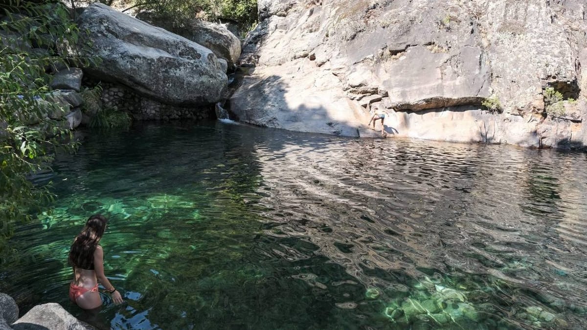 Una mujer bañandose en las piscinas naturales de Arenas de San Pedro