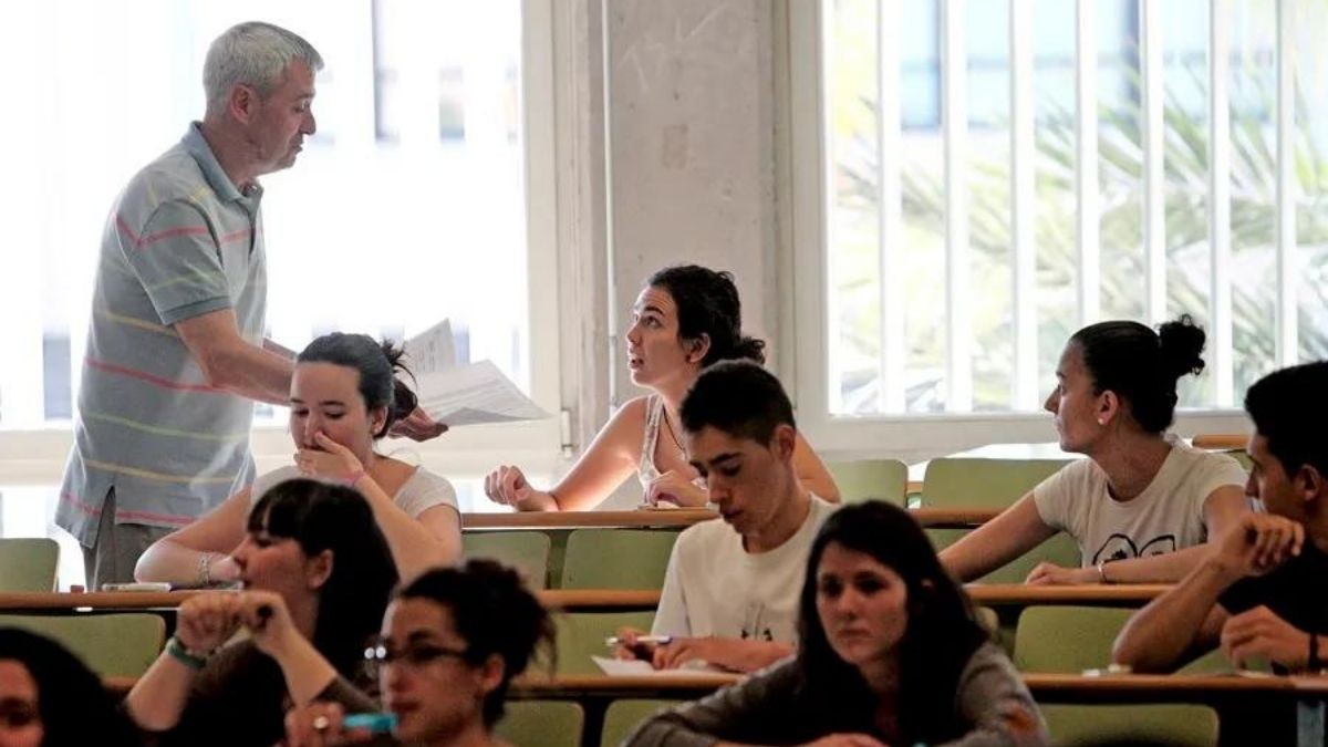 Profesor entregando exámenes en clase