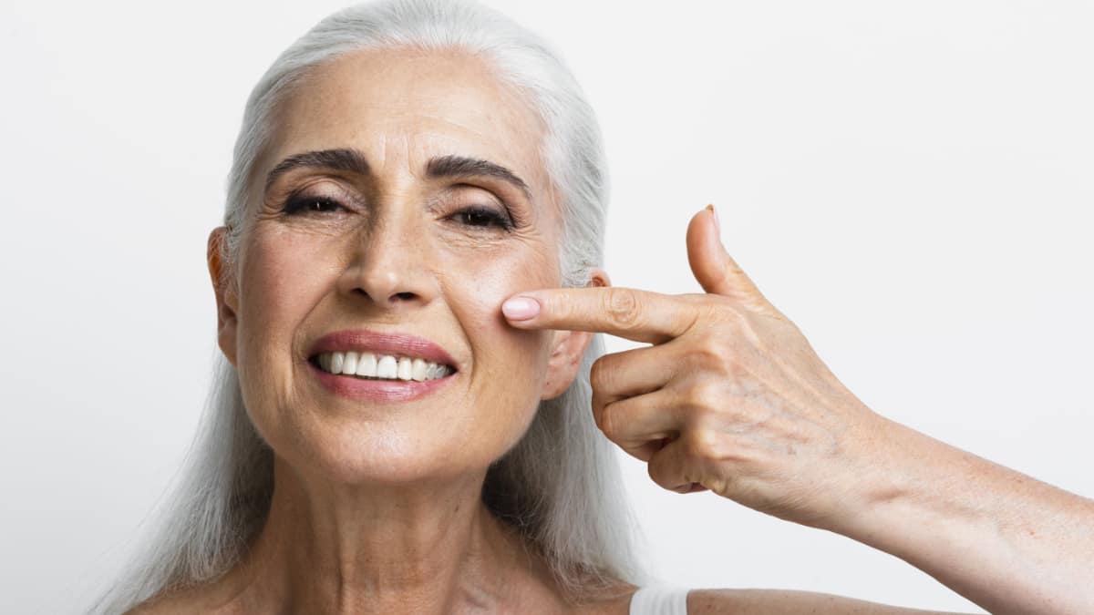 Mujer senior usando un crema antiedad