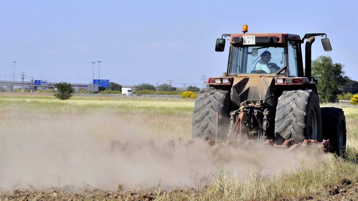 Un agricultor trabaja conduciendo un tractor.