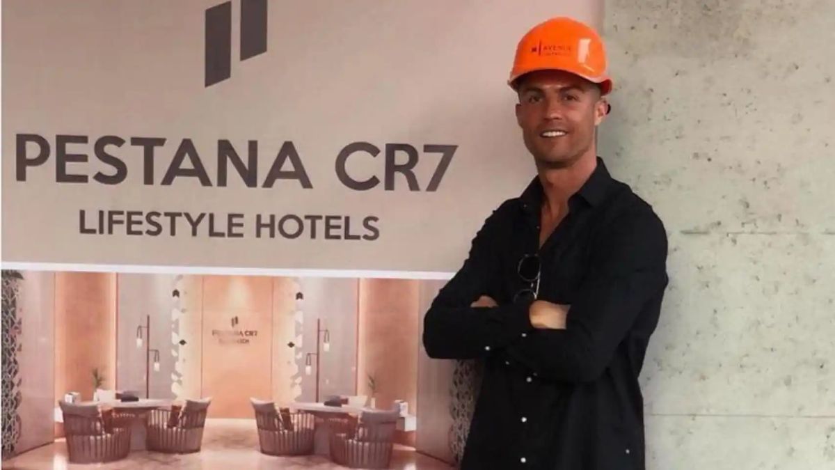 Cristiano Ronaldo, con casco, al lado de un cartel de su hotel