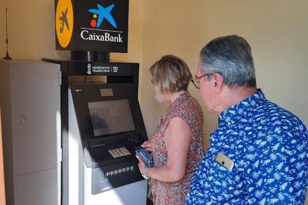 Clientes Caixabank retirando dinero del cajero