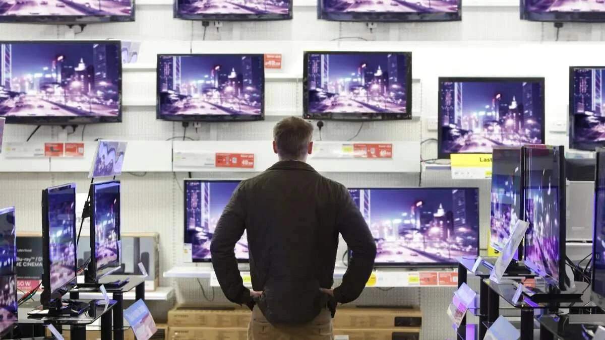 Hombre mirando televisores para comprar en Black Friday 