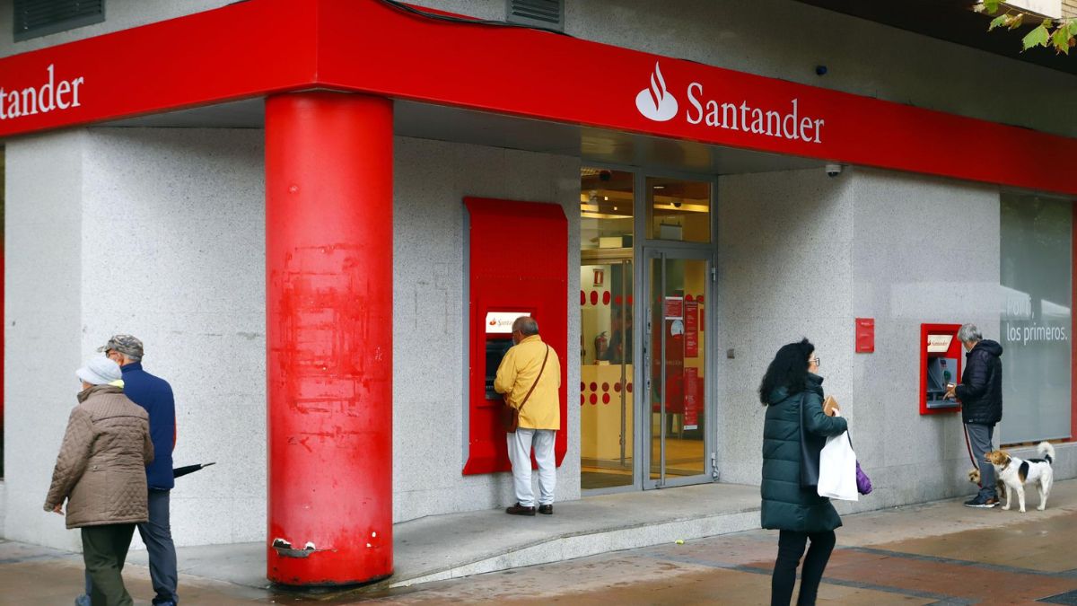 Entrada a un banco santander, con personas paseando.