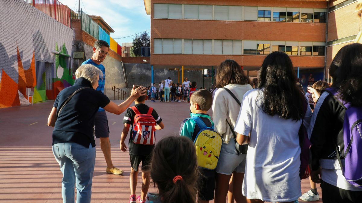 Un grupo de alumnos con su profesor a la entrada del colegio.