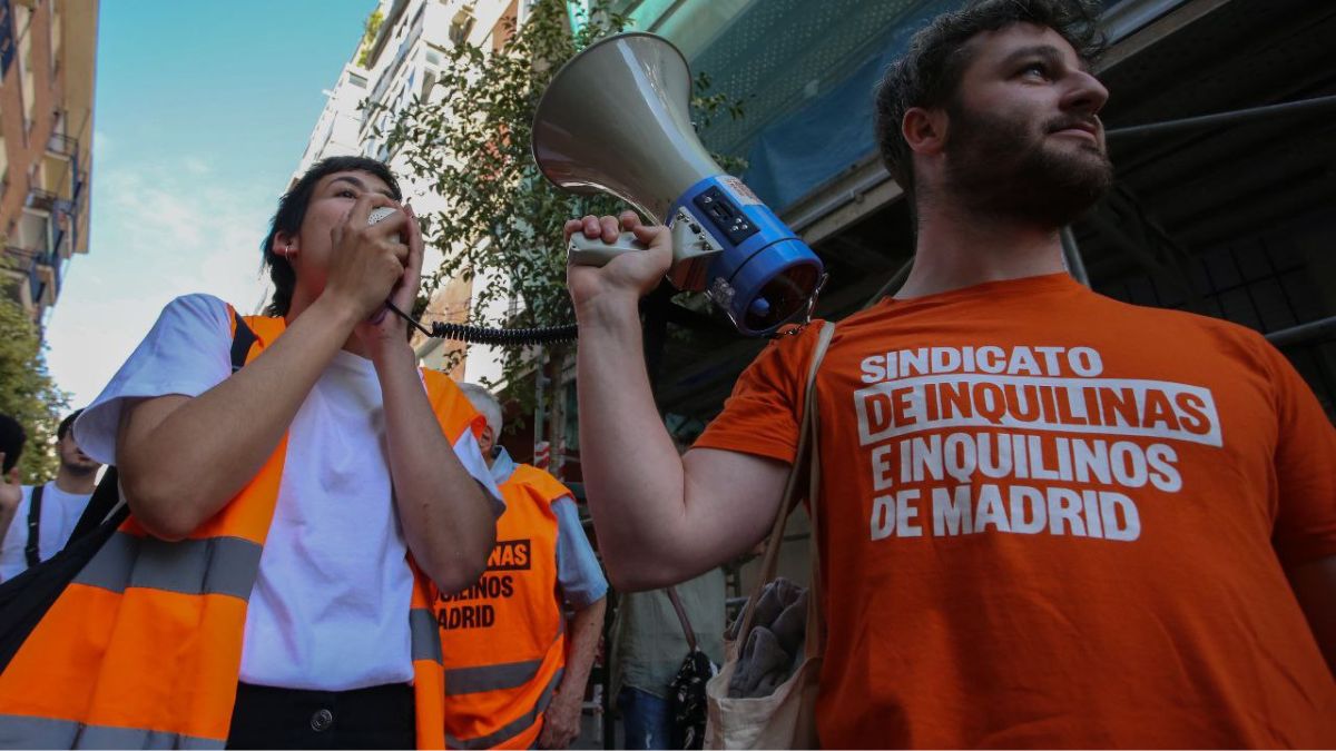 Hombre sujeta altavoz a una mujer que habla.