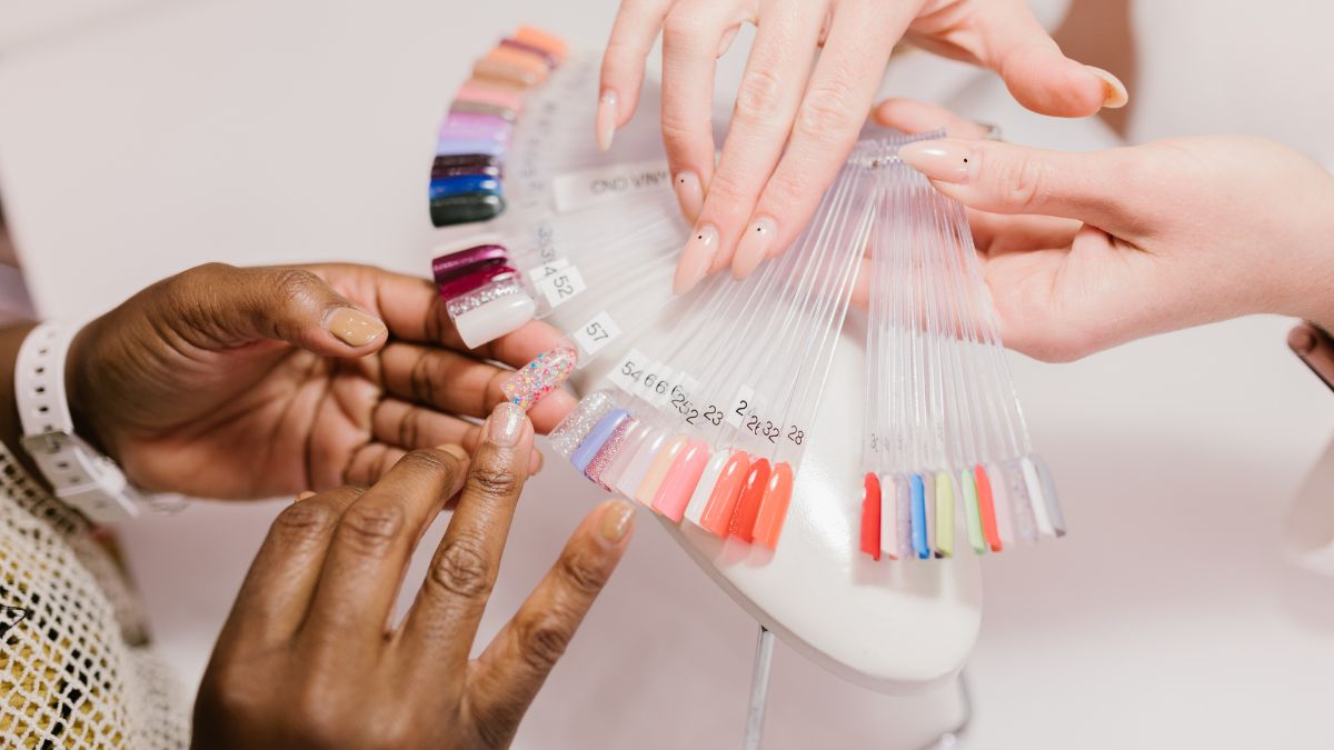 Mujeres escogen el color de las uñas para una manicura.