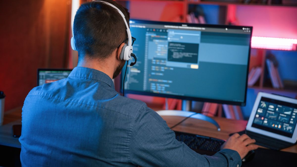 Un programador trabaja desde su casa con los auriculares puestos.