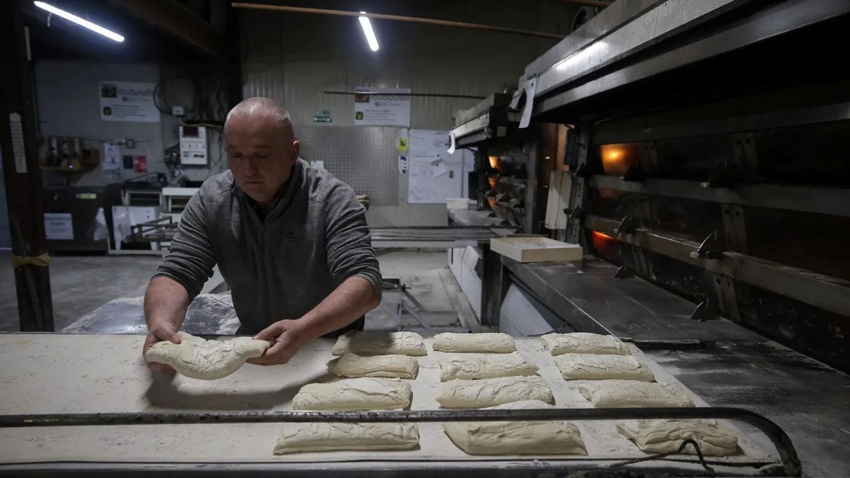 El propietario de la panadería trabaja amasando pan