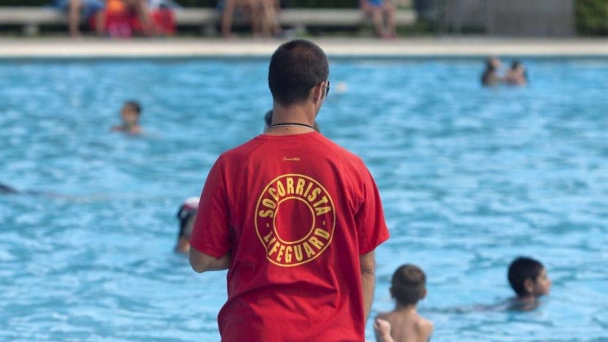 Un socorrista vigila a un grupo de niños en una piscina.