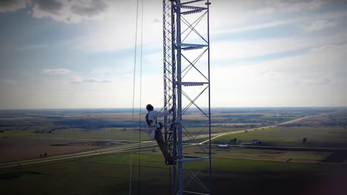 Trabajador subiendo por la torre de comunicaciones.